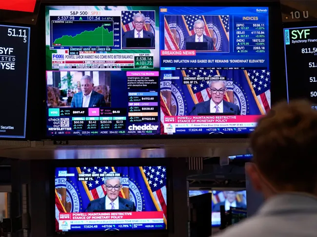 A bank of television screens on the floor of the New York Stock Exchange, shows Federal Reserve Chairman Jerome Powell